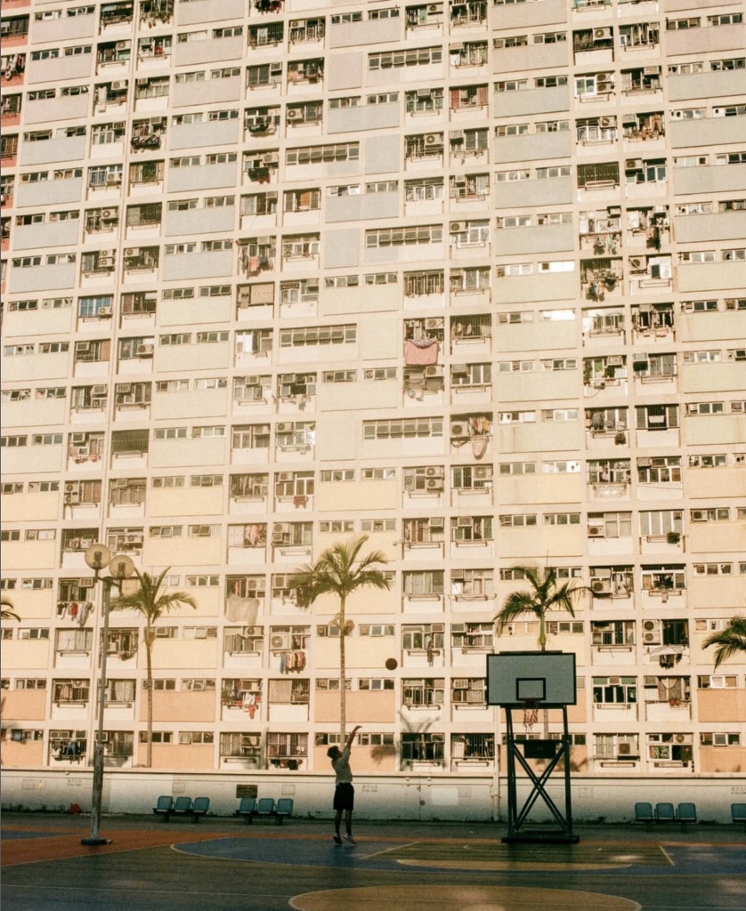 apartment building with basketball court in front