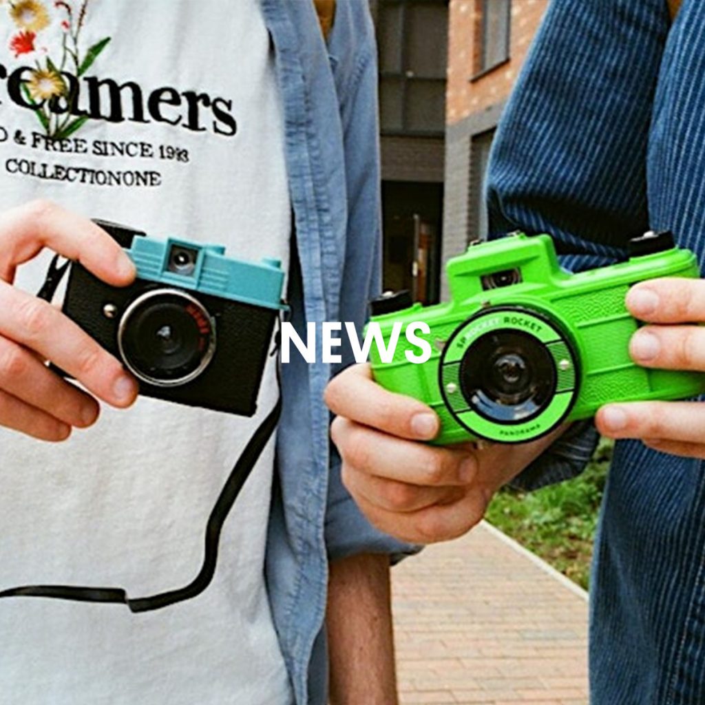 Two people holding lomography cameras.