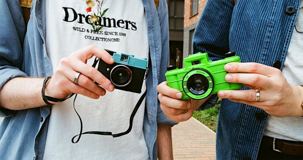 Two people holding lomography cameras.