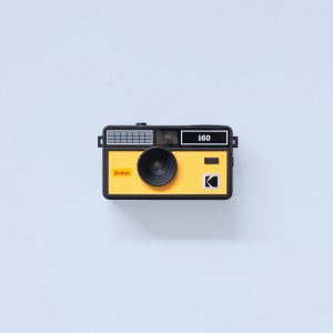 Kodak i60 35mm Film Camera Yellow & Black Flash Down on blue background